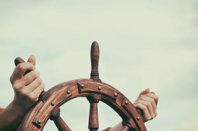 Hände steuern mit einem Holzsteuerrad eines alten Segelschiffs